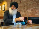Man Sat With A Hot Drink Inside A Cafe