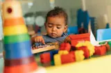 Young Child Playing With Colourful Objects